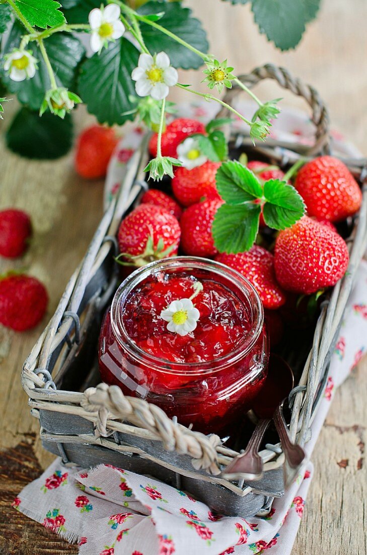 Erdbeeermarmelade und frische Erdbeeren in einem Körbchen