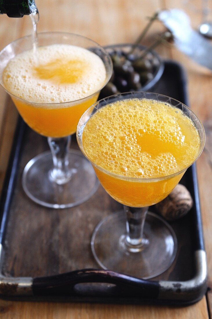 Two Prosecco cocktails made with orange and apricot juice