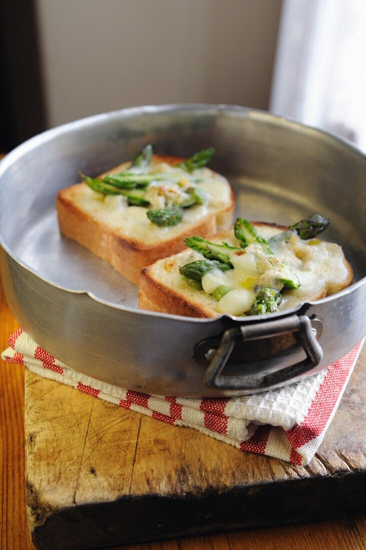 Toast topped with green asparagus, gorgonzola and mozzarella