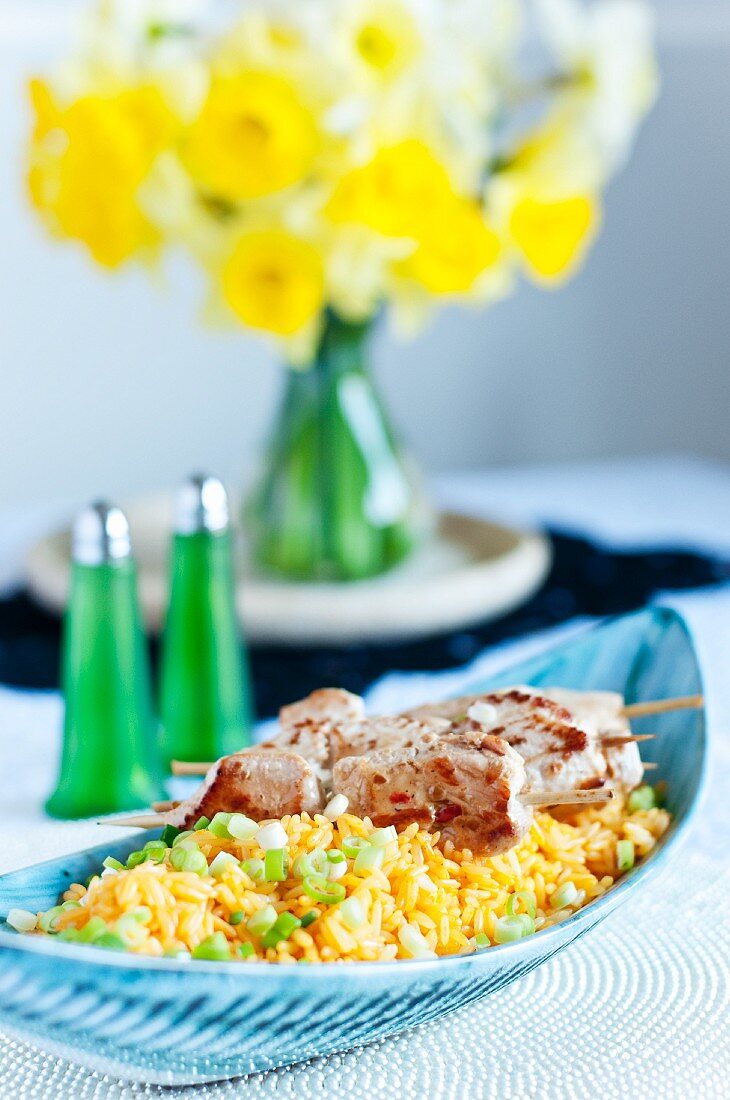 Hähnchenspiesse mit Erdnüssen und gelber Curry-Reis mit Frühlingszwiebeln