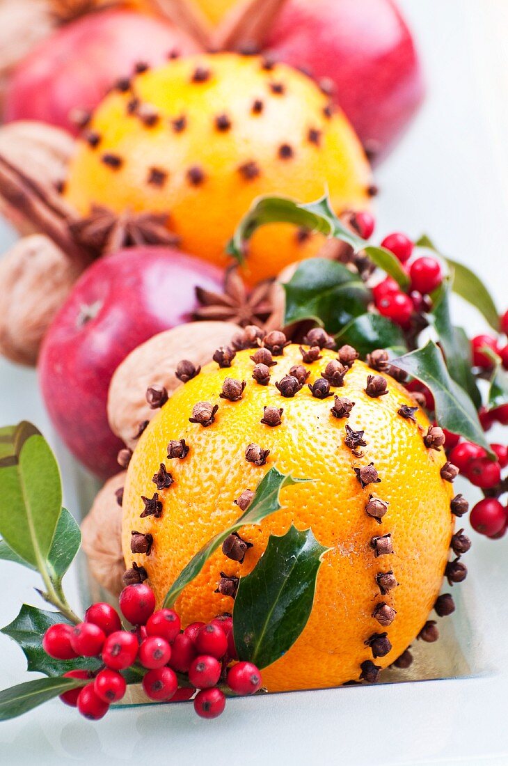 Orangen mit Nelken gespickt, Ilexbeeren, Äpfel, Walnüsse, Sternanis und Zimtstangen