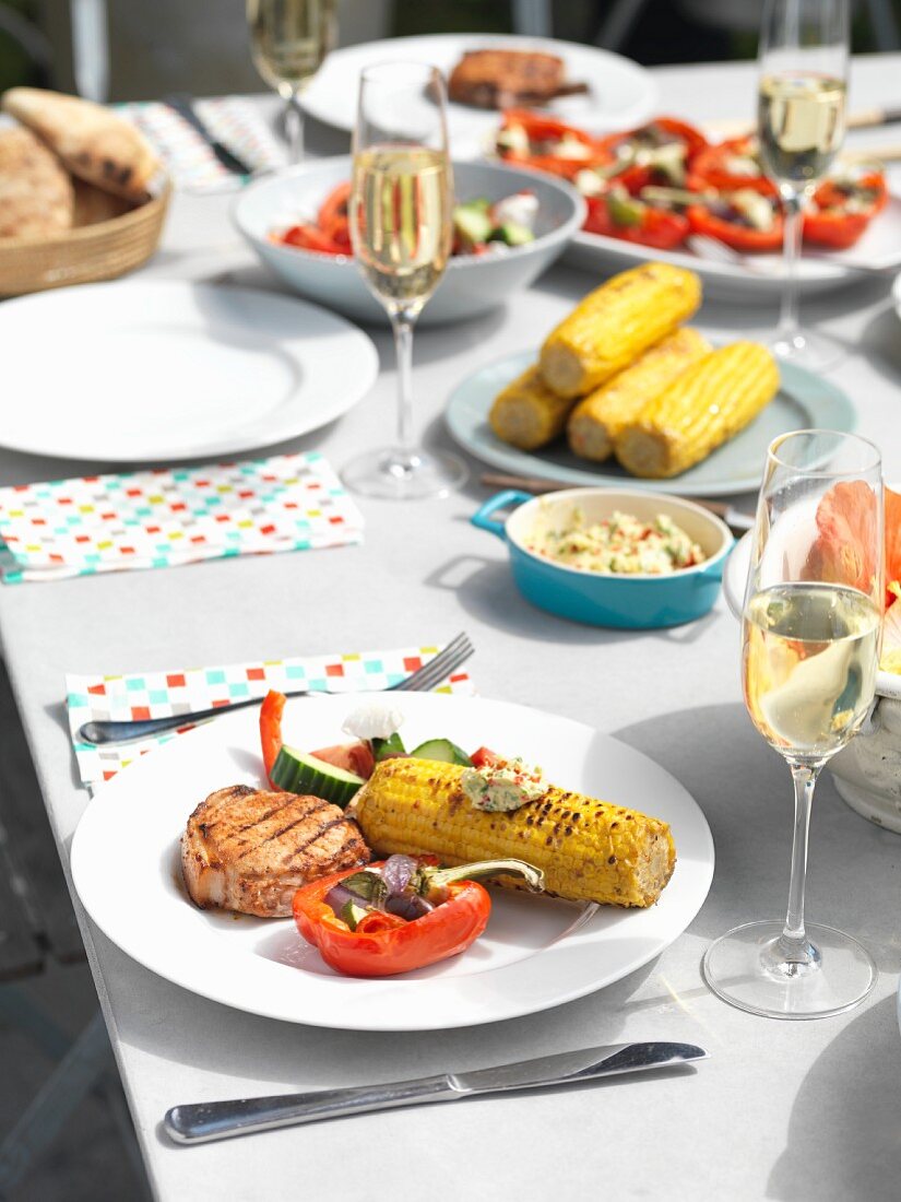 A table laid with grilled food in a garden