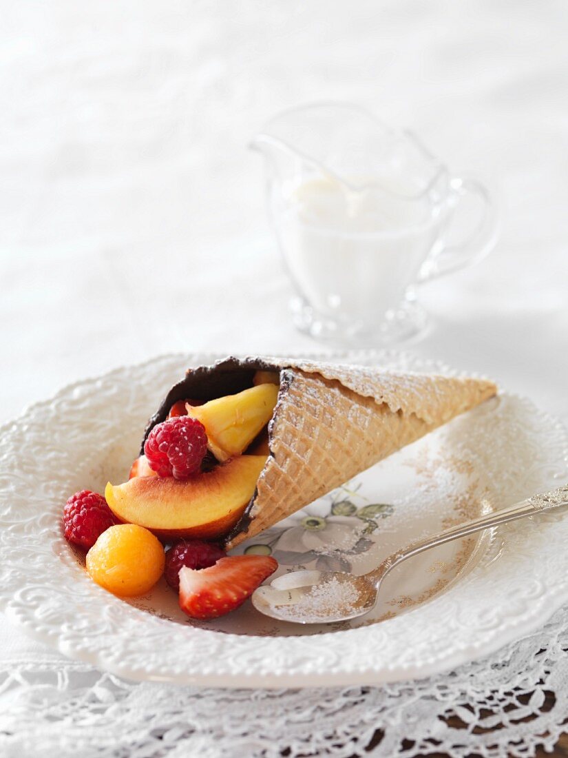 An ice cream cone filled with chocolate and fruits