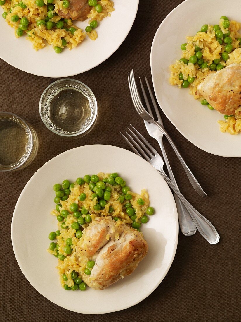 Plates of Chicken Served with Rice and Peas