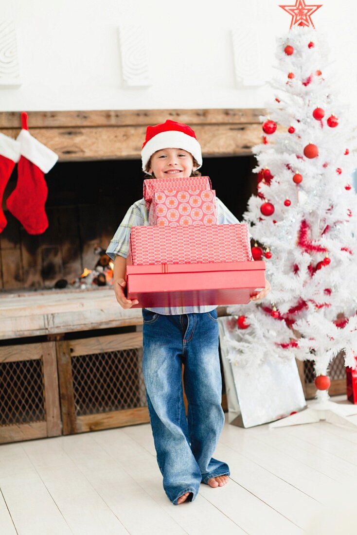 Boy in Santa hat with Christmas gifts