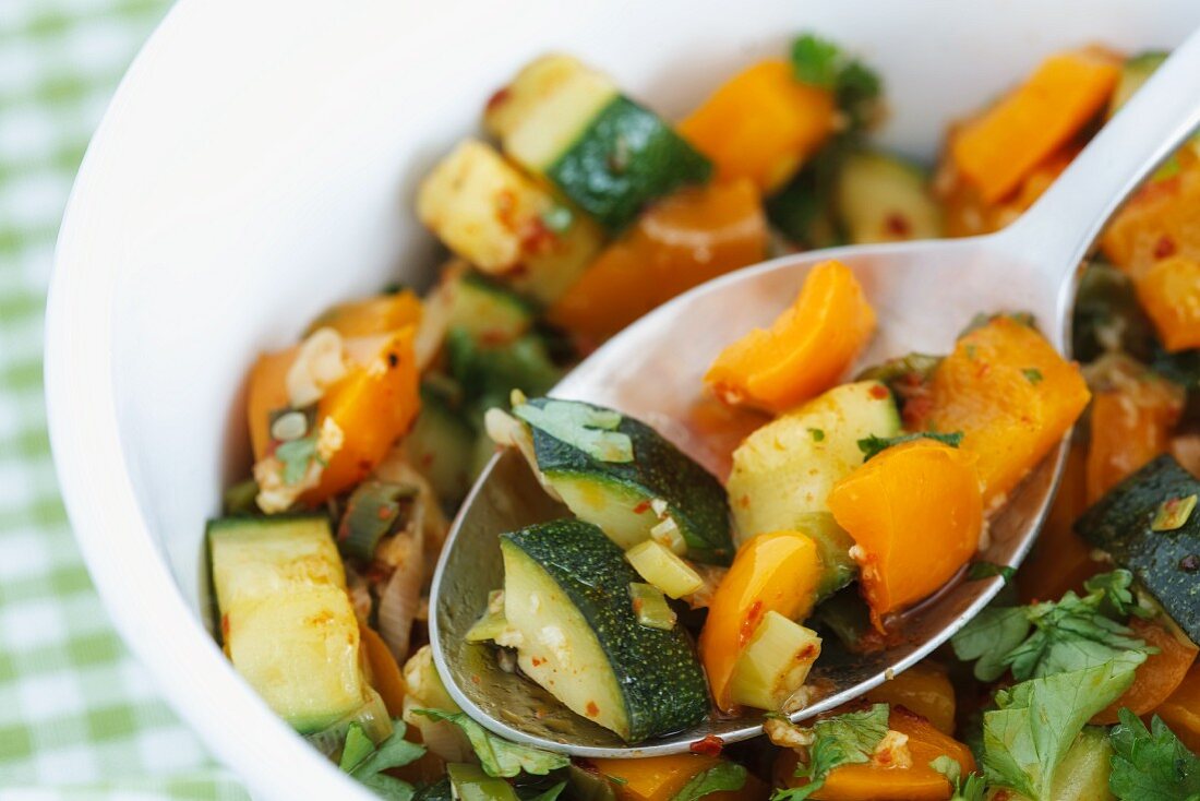 Gedünstetes Gemüse: Zucchini, Frühlingszwiebeln, orangefarbene Paprika (Close Up)