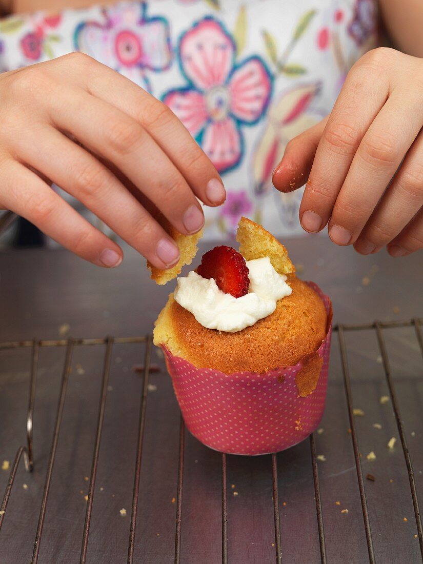 A cupcake being decorated