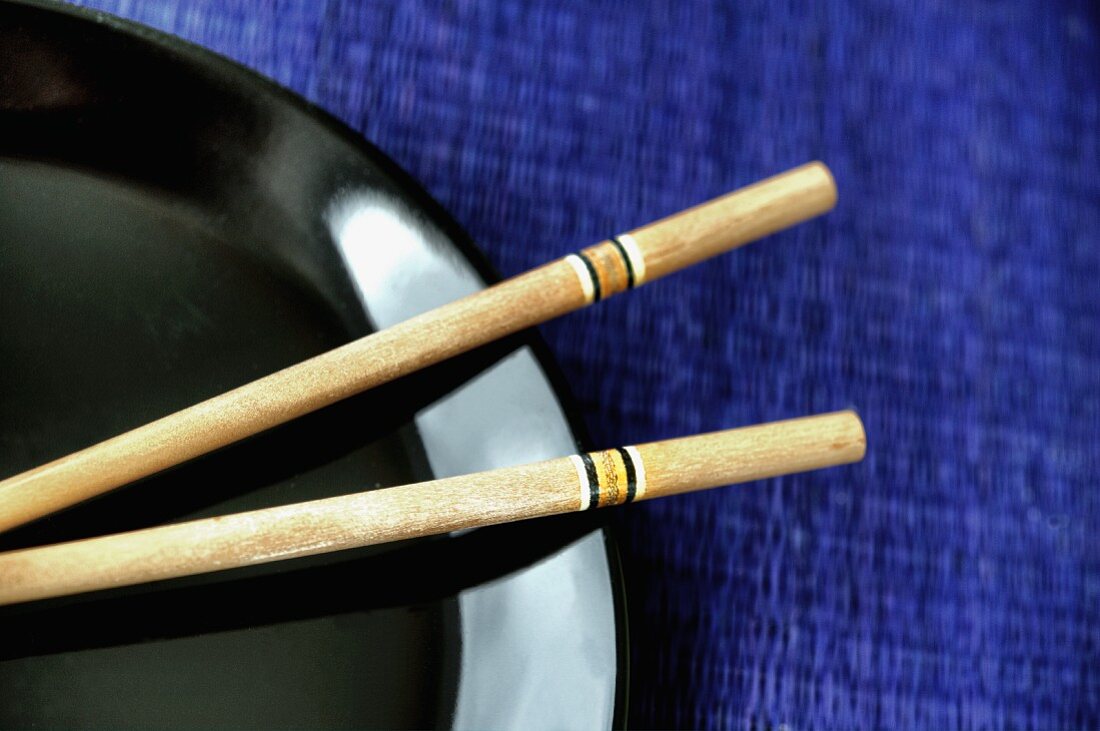 Chopsticks on a black plate