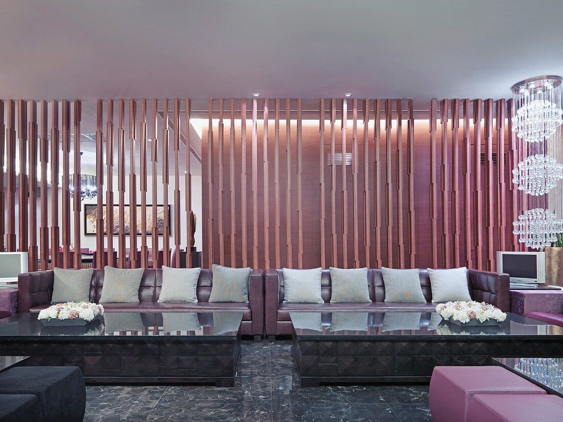 Megasofas mit grauen Kissen vor Lamellentrennwand in klassisch modernem Loungebereich