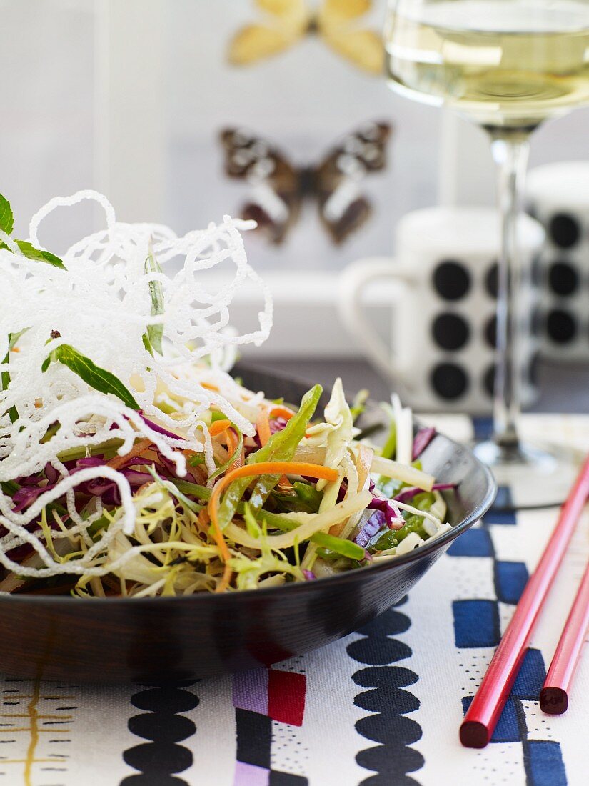 Bowl of Asian Salad with Red Chopsticks