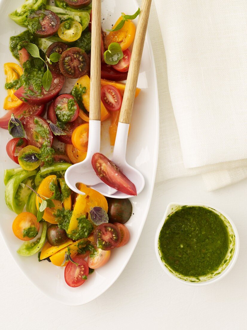 Tomato Salad with Pesto; On a Serving Dish with Salad Servers