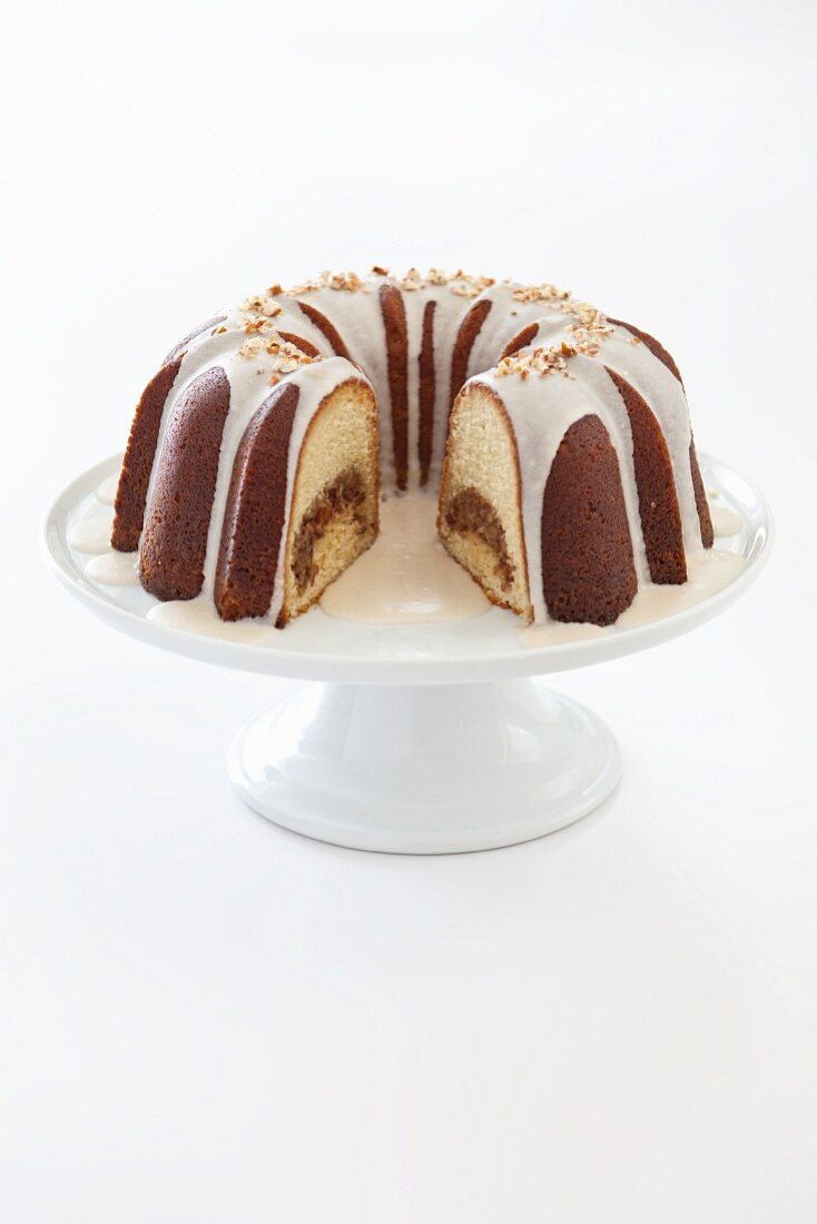 Rum Bundt Cake with Icing on a Pedestal Dish with Slice Removed