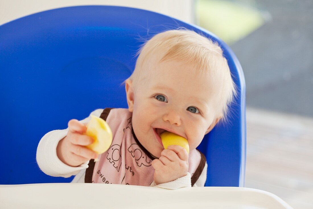 A baby eating an apple