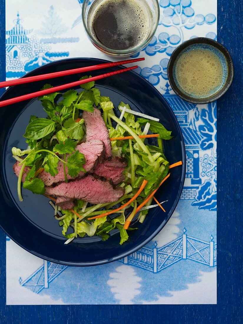 Asian Beef Salad on a Blue Plate with Chopsticks; From Above
