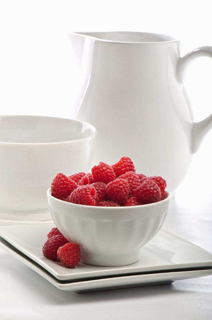 A Bowl of Fresh Raspberries with Bowl and Pitcher