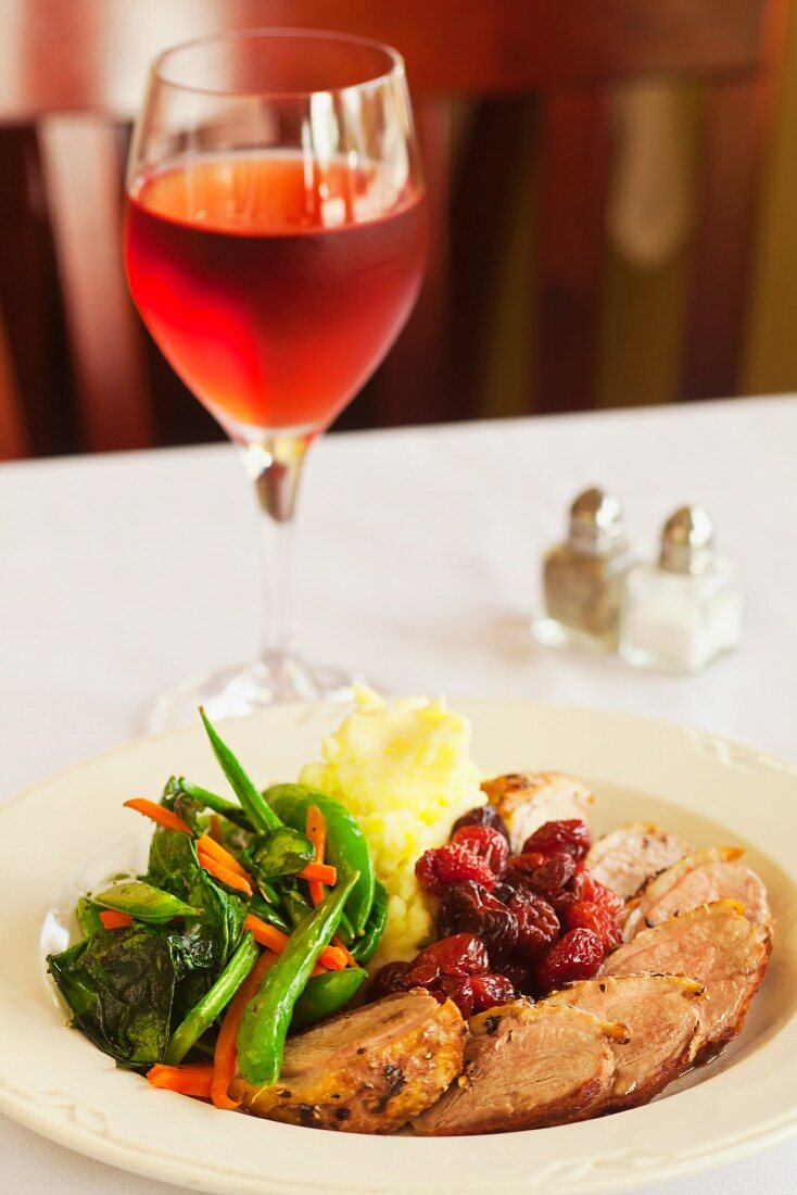 Entenbrust mit Kirschen, Kartoffelpüree und Gemüse, Roseglas