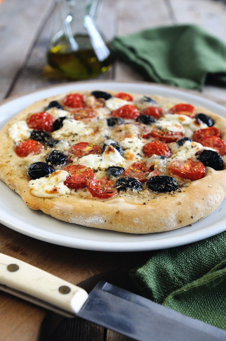 Pizza mit Oliven, Kirschtomaten und Mozzarella