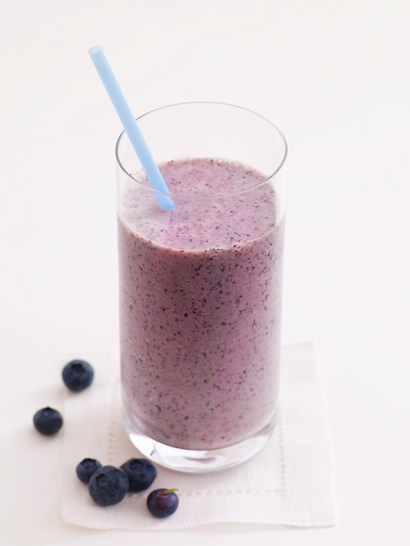 Blueberry Smoothie in a Glass with a Straw; Fresh Blueberries
