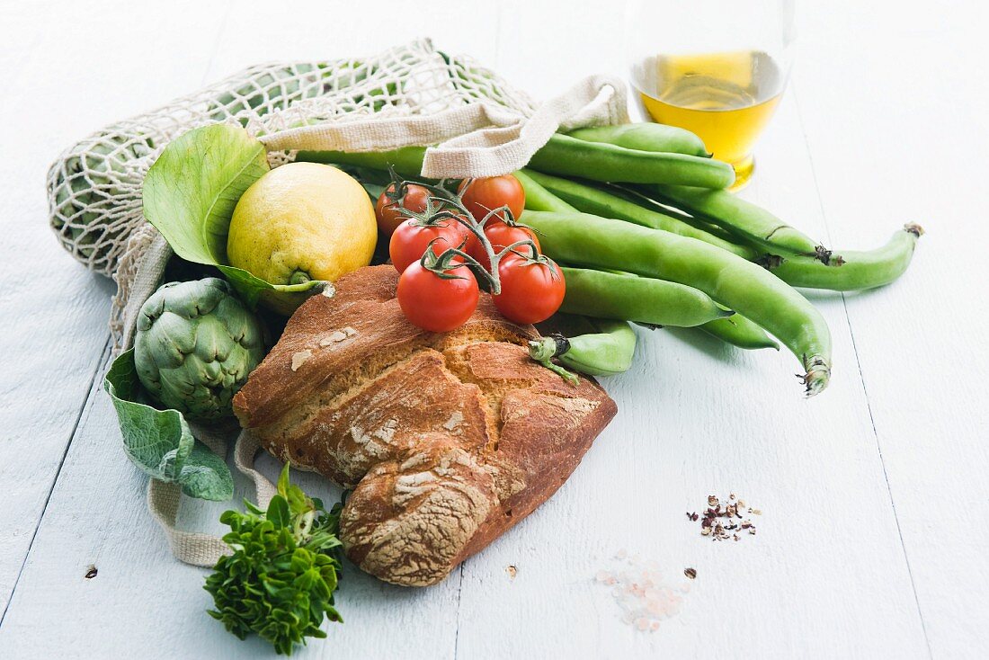 Einkaufsnetz mit Brot, Gemüse und Zitrone