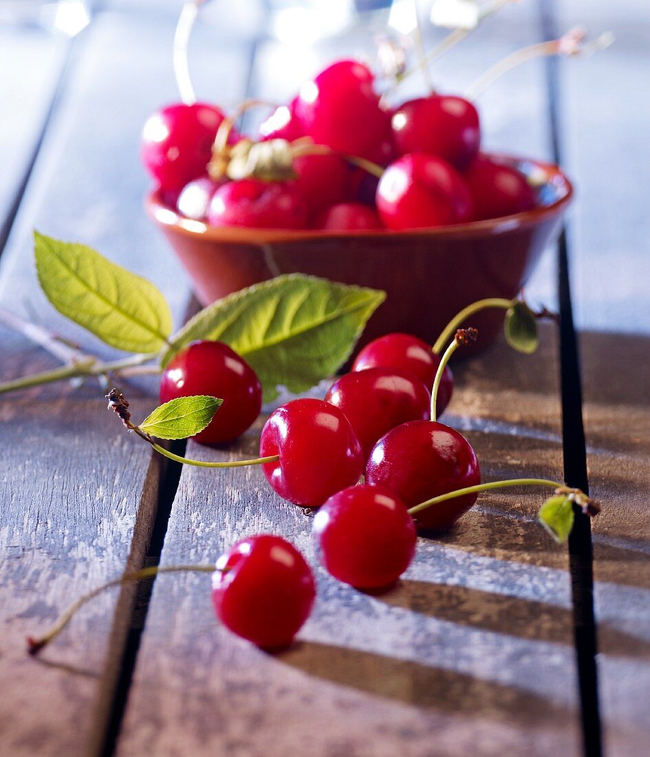 Cherries in a bowl and in front of it