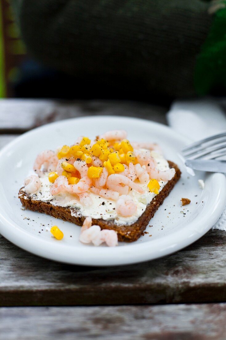 A slice of bread topped with remoulade, shrimps and sweetcorn
