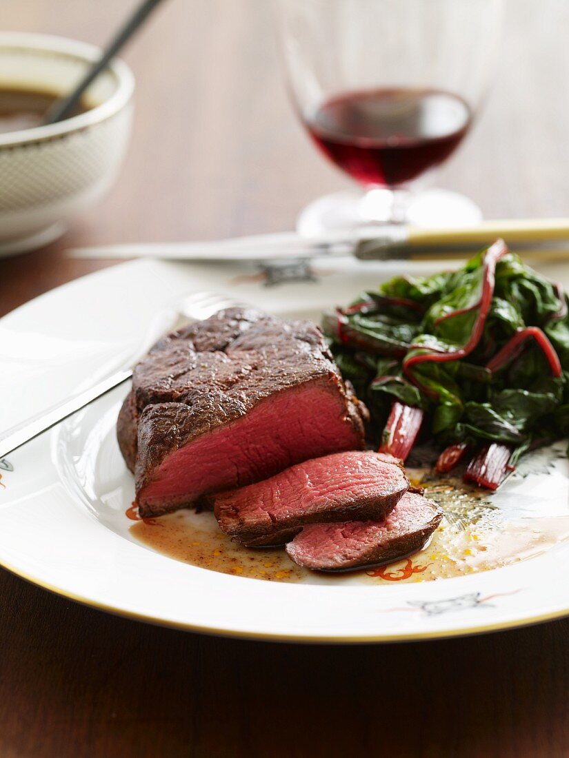 Partially Sliced Steak Cooked Rare with Beet Greens