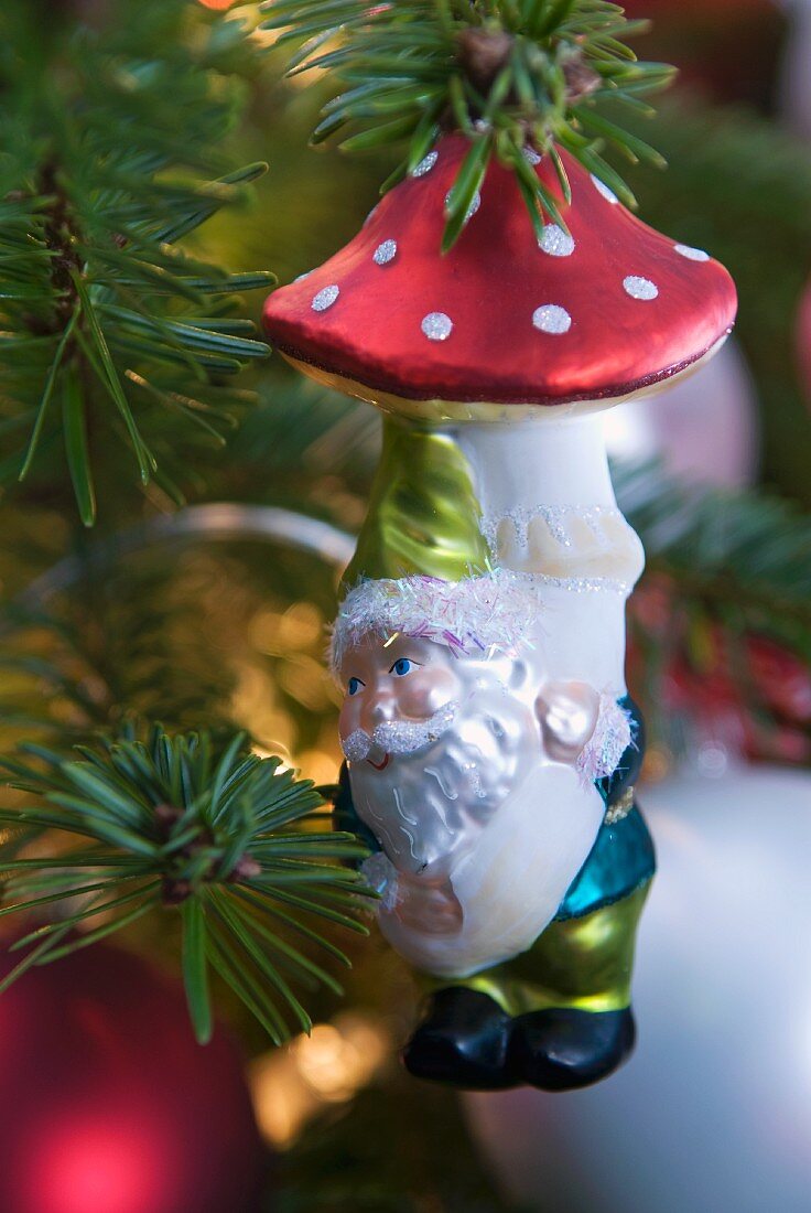 Bauble with dwarf motif hanging from fir branch