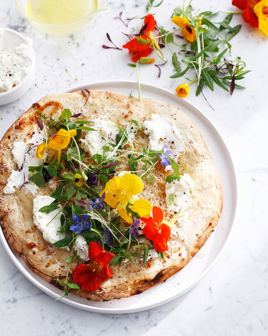 Pizza mit Frischkäse und Essblüten