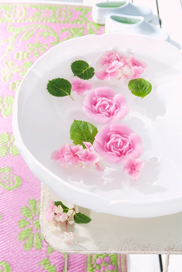 Rose-shaped, scented floating candles in bowl of water