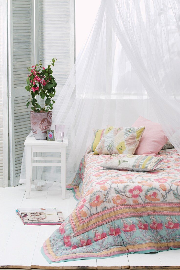 Floral bedspread on canopied bed
