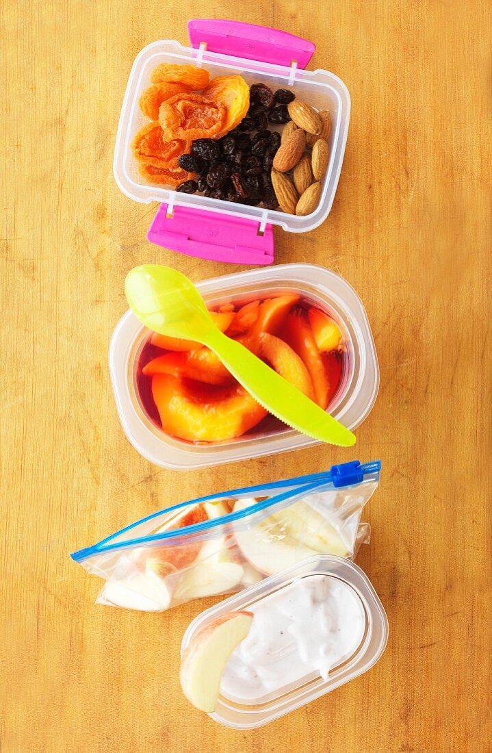 Gesunde Lunchbox mit Obst, Joghurt und Trockenfrüchten