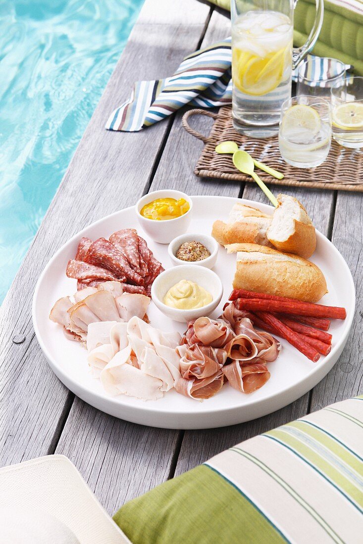 Plate of sliced meats, bread and mustard