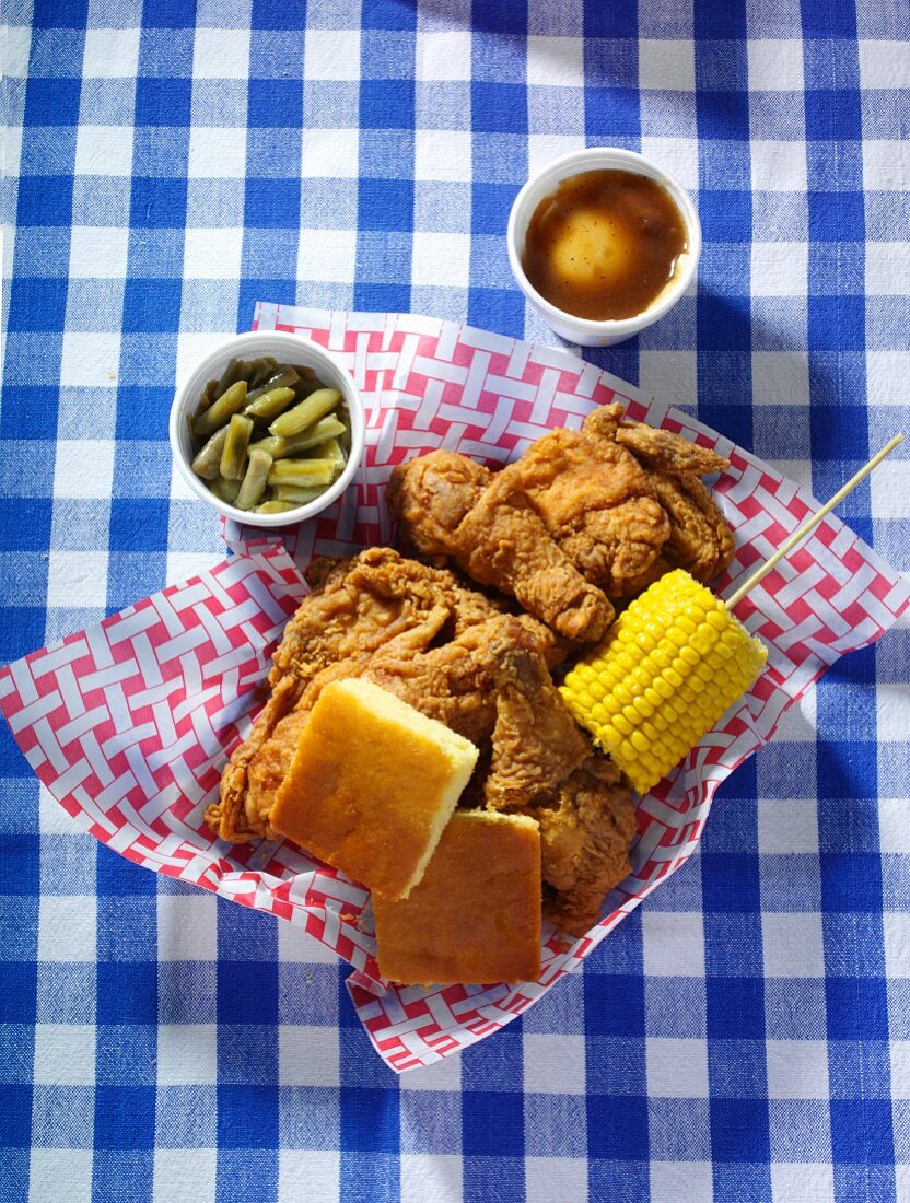 A Basket of Fried Chicken with Corn Bread, Corn on the Cob and Mashed Potato with Gravy