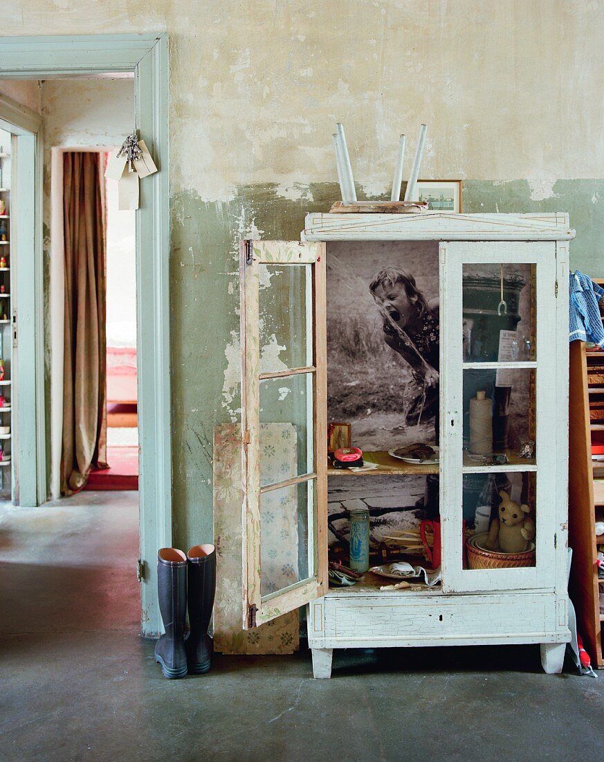 Old, glass-fronted cupboard with photographic print on back wall