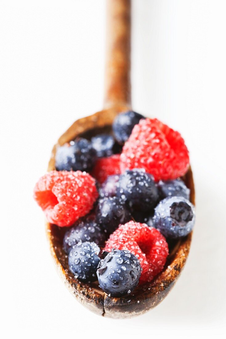 Washed Raspberries and Blueberries on a Wooden Spoon