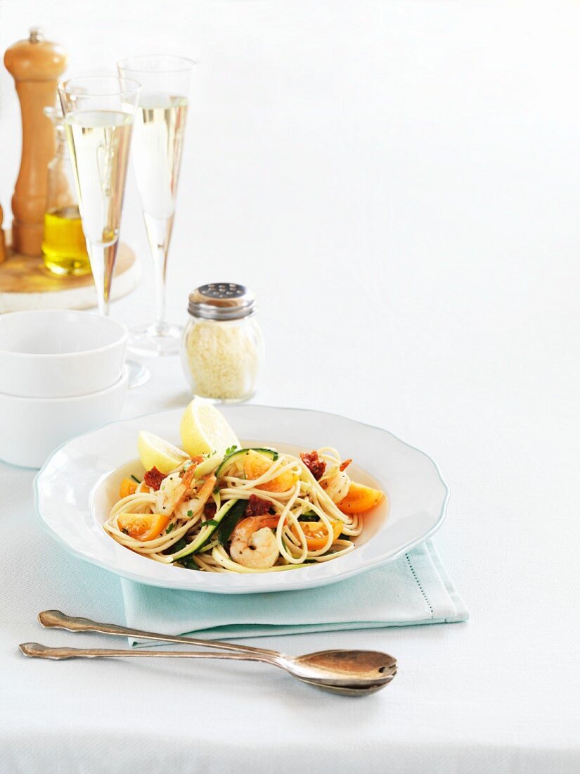 Spaghetti with king prawns and glasses of champagne