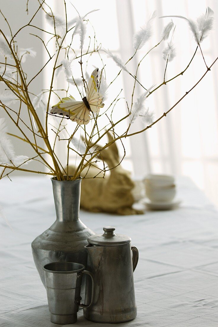 Zweige mit Schmetterlingen und Federn dekoriert in Vintage Vase