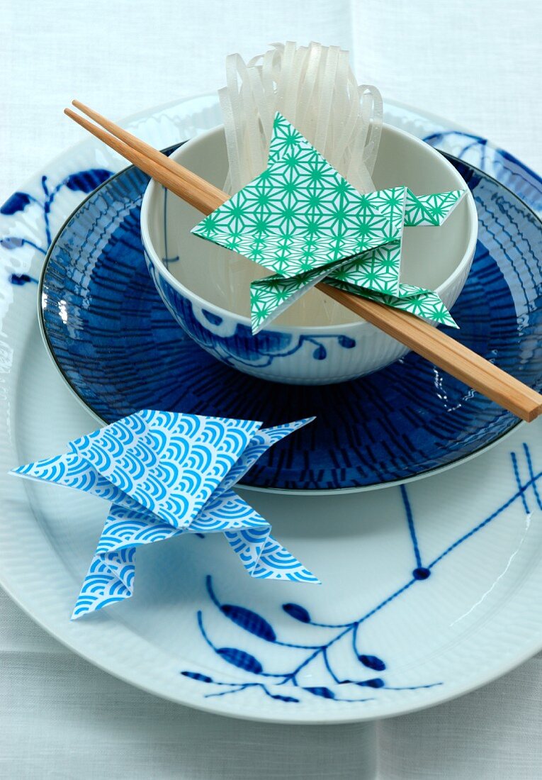 An Asian place setting with chopsticks and origami shapes