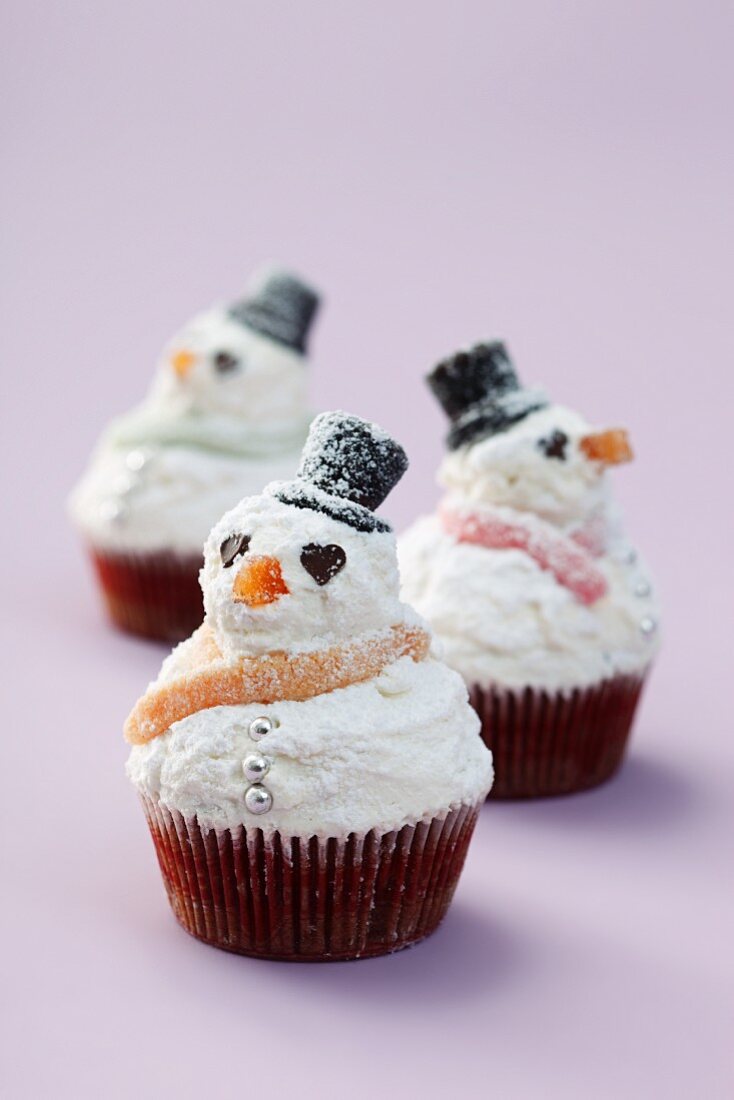 Snowman cupcakes on a purple surface