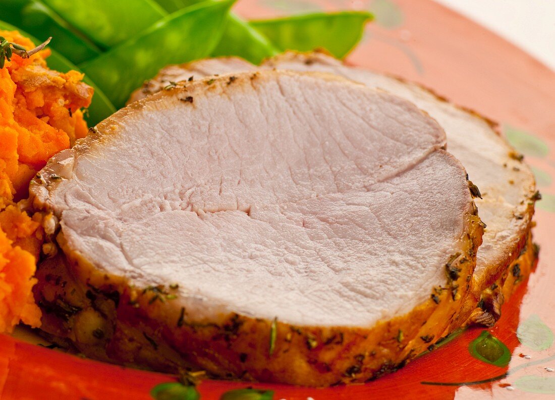 Slices of Roast Pork Loin with Mashed Sweet Potatoes and Snow Peas