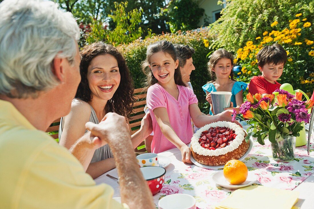 A family having coffee and cake at the garden table