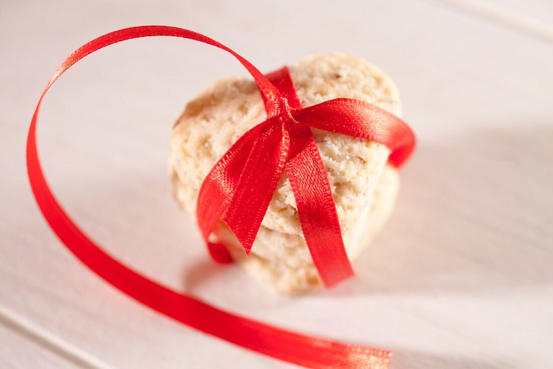 A heart-shaped biscuit tied with a red ribbon