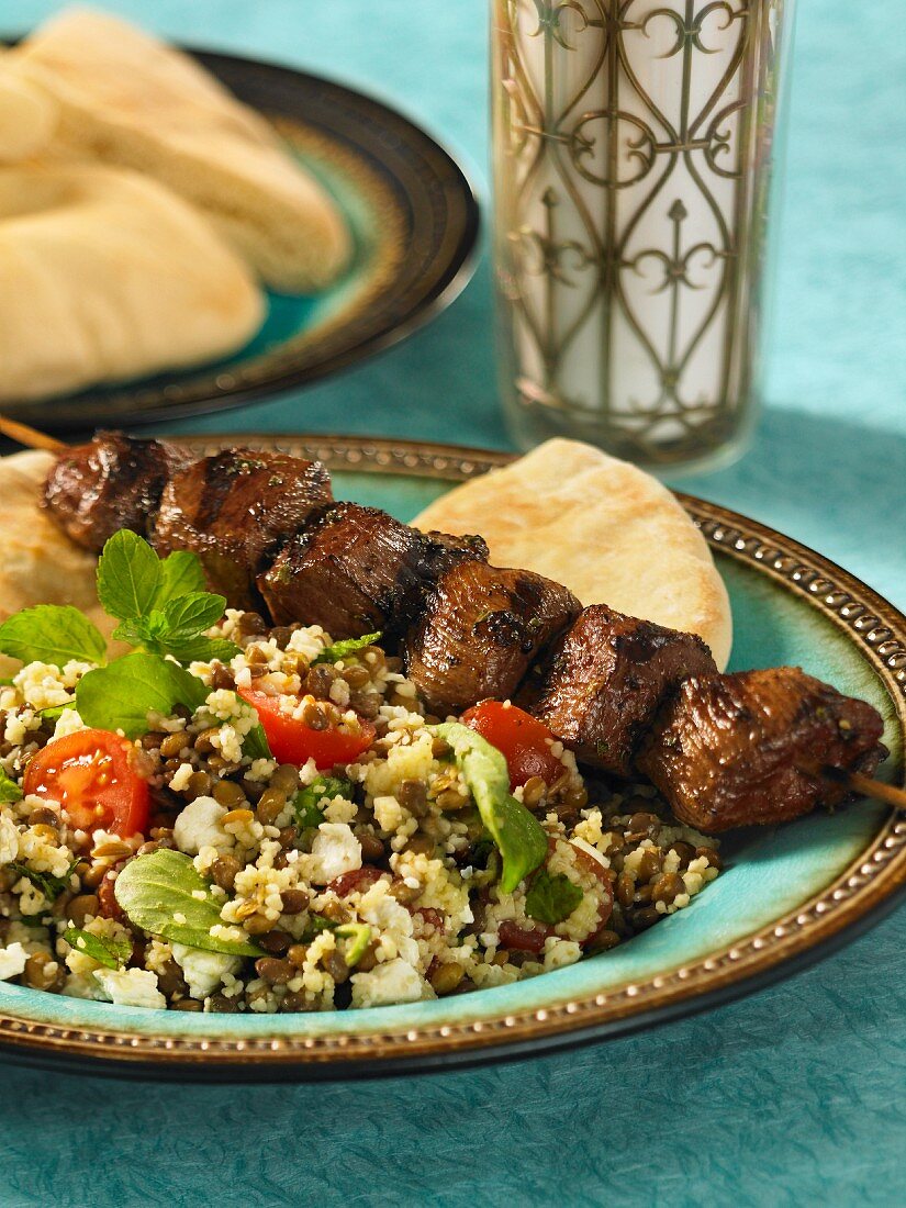 Grilled beef kebab with a couscous and lentil salad