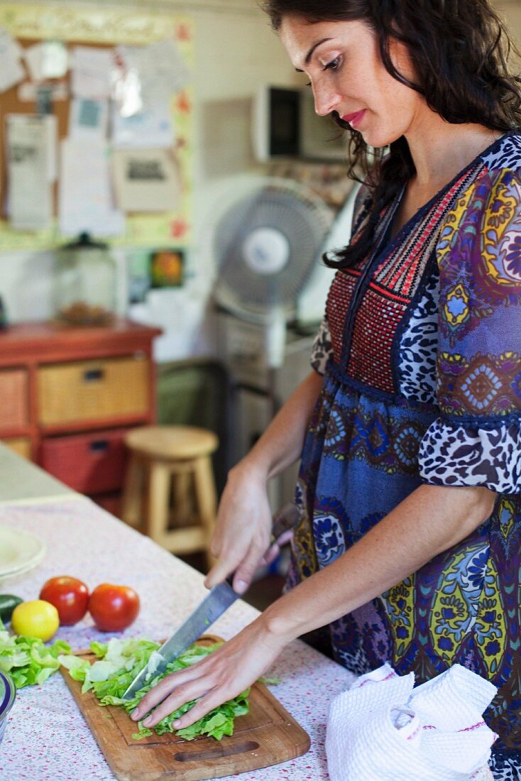 Frau schneidet Blattsalat