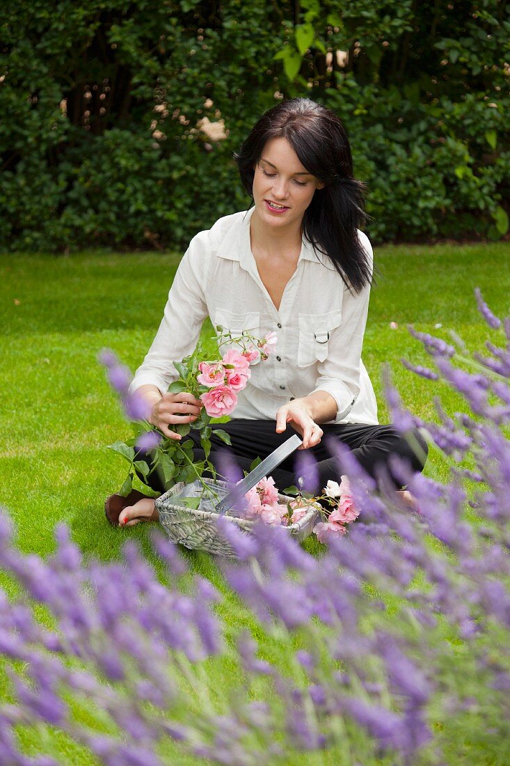 Woman with basket of flowers in backyard