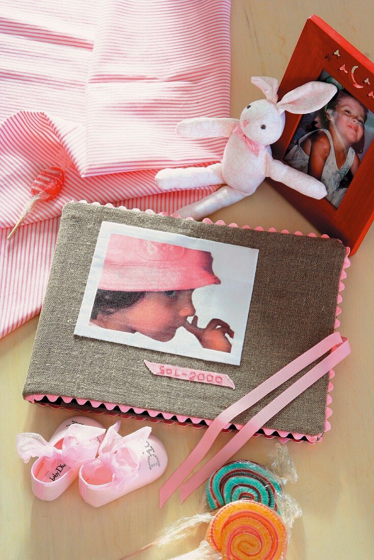 Photo album with hand-crafted cover amongst toys and sweets