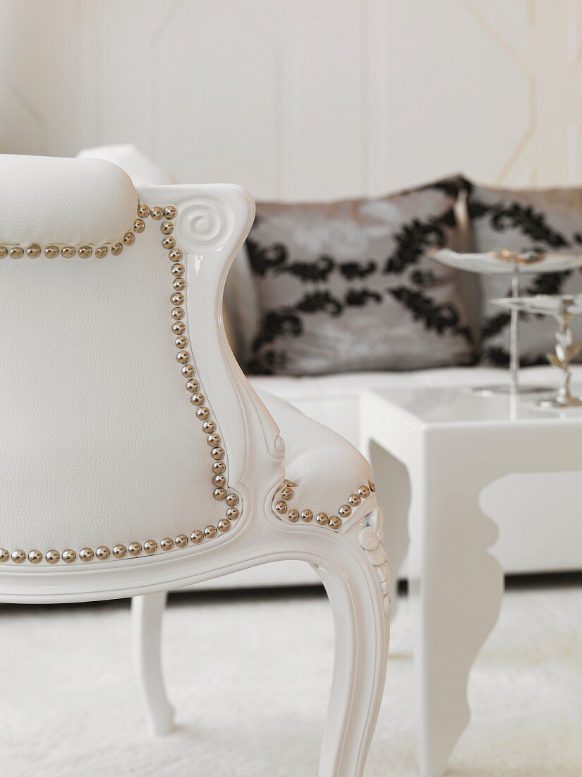 Neo-baroque chair with curved wood frame and riveted white leather upholstery