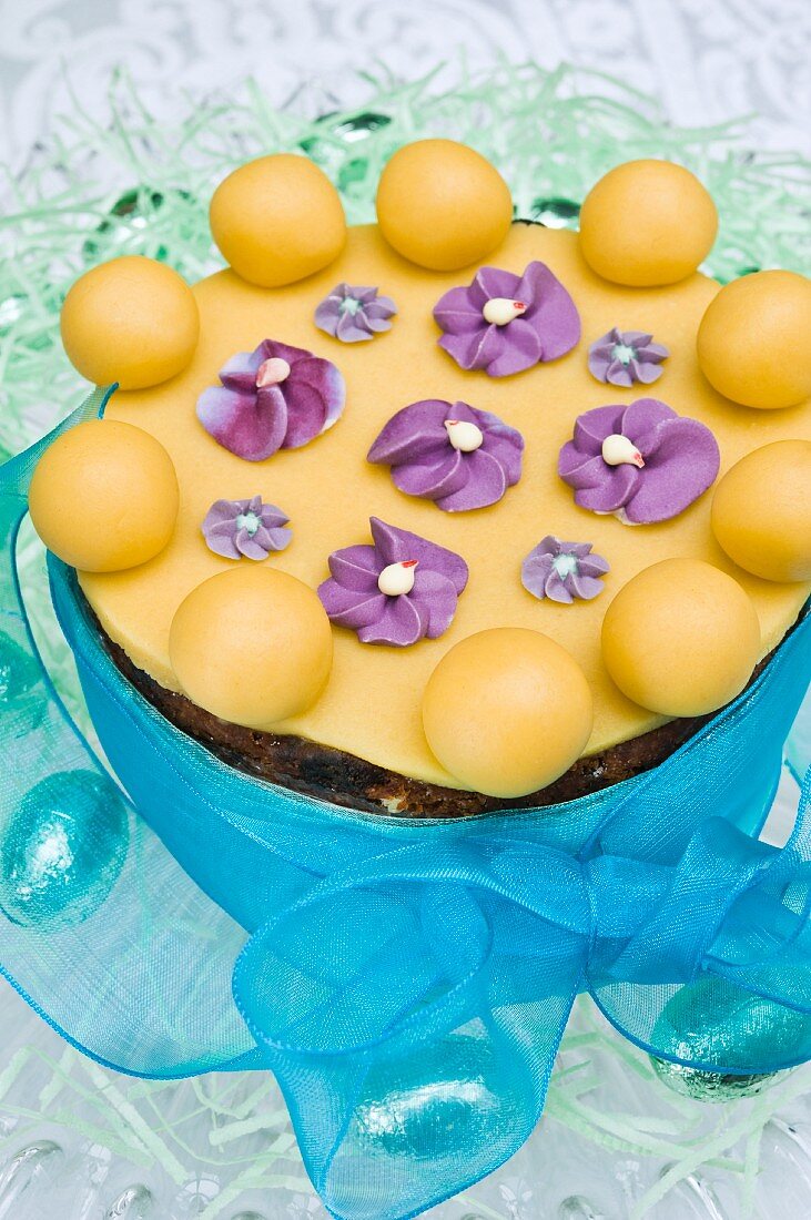 An Easter fruit cake decorated with marzipan balls and sugar violets
