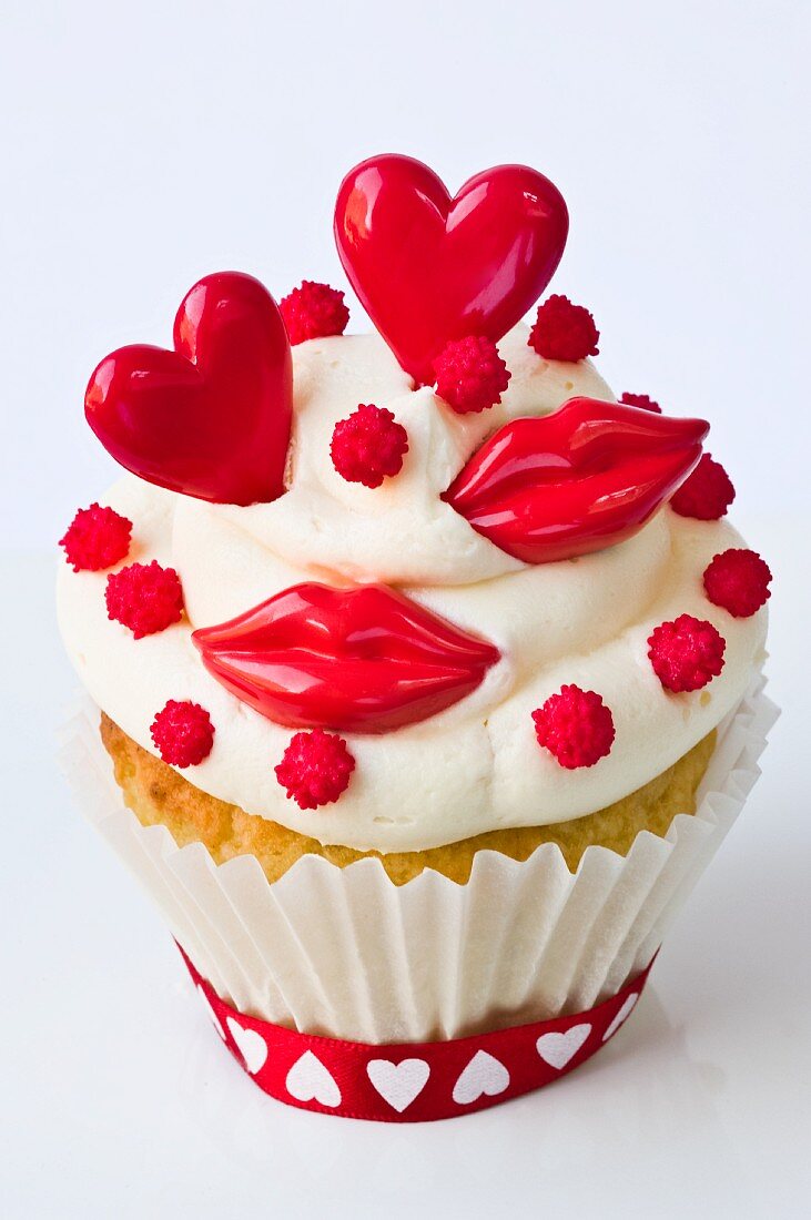 A cupcake decorated with red lips and hearts for Valentine's Day