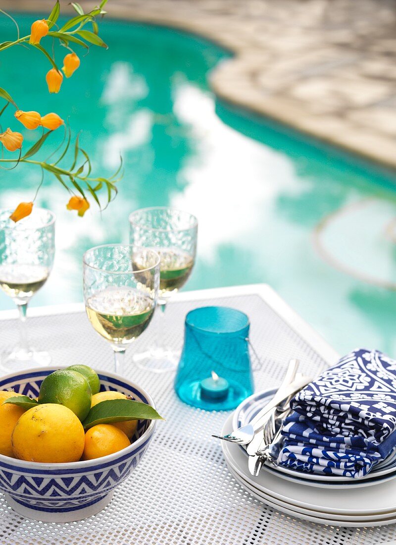 A summery table laid by a swimming pool